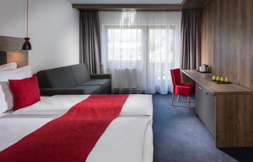 a hotel room with a large bed and a desk at Hotel Höhlenstein in Tux