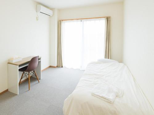 a bedroom with a bed and a desk and a window at Hotel Morimotoya Itano - Vacation STAY 05548v in Kamiita