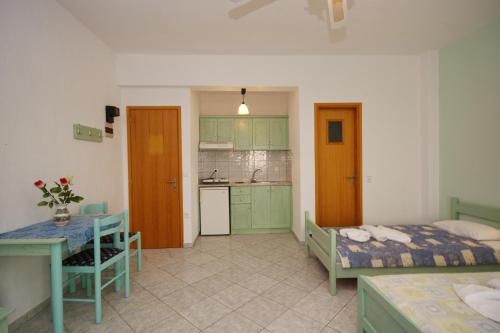 a bedroom with a bed and a table and a kitchen at Myriam Studios in Patitiri