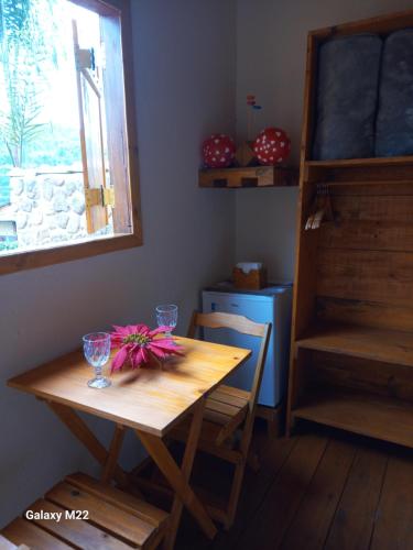 un tavolo di legno con bicchieri e un fiocco rosa sopra di Cabana refúgio da juruti 08 a Cunha