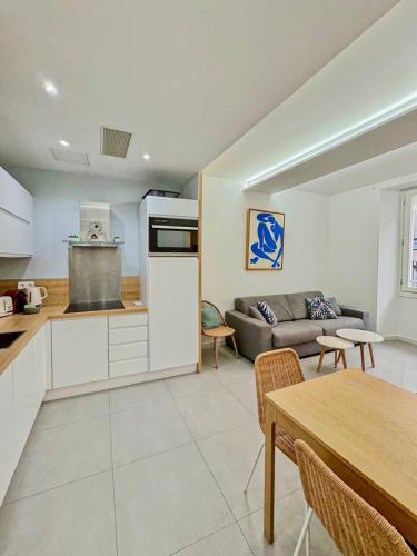 une cuisine et un salon avec un canapé et une table dans l'établissement Vieux Nice - Wifi, AC, 6pers, à La Celle-sous-Gouzon