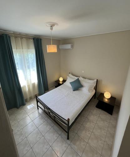 a bedroom with a bed with two tables and two lamps at Margaret's House in Kefallonia