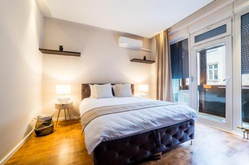 En eller flere senge i et værelse på Maison Eleven Central 2-Bedroom Apartment with Balcony and Private Parking