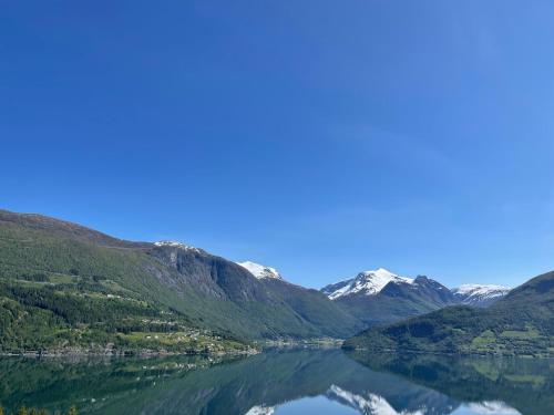 a view of a lake with snow covered mountains at Olden Tinyhouse - Modern Living in Olden