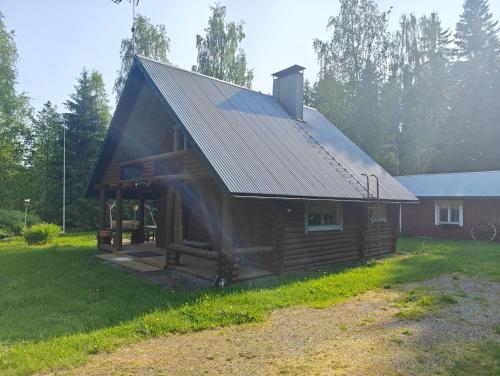 a log cabin with a metal roof on a yard at Merikarviantupa1 in Pori