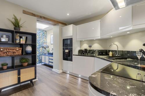 a kitchen with white cabinets and a counter top at La Petite Maison Apartments in Brixham