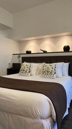 a bedroom with a large bed with white sheets and pillows at BHB Hotel Boutique in Santiago