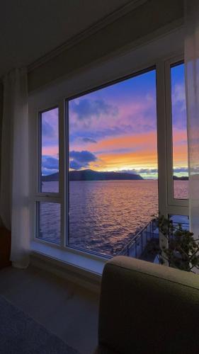 a room with a window with a view of the ocean at Ny leilighet i Ålesund med fantastisk utsikt in Ålesund