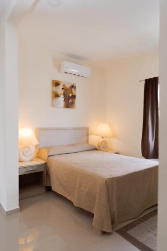 a bedroom with a bed with two lamps on it at Saules Sueño in Cancún