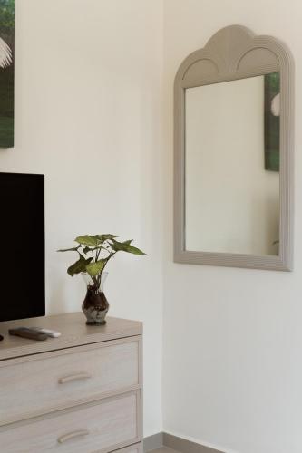 a bedroom with a dresser with a mirror and a tv at Saules Sueño in Cancún