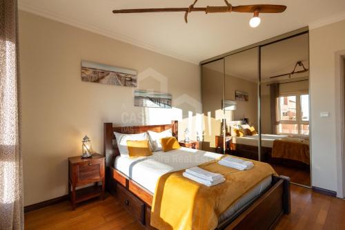 Un dormitorio con una cama y un espejo grande. en Casa de S Sebastiao by ACasaDasCAsas, en Ericeira