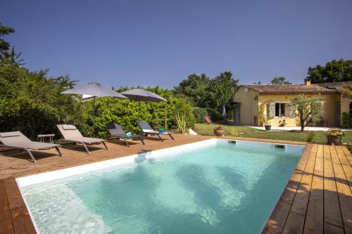 une piscine avec des chaises et une maison dans l'établissement Villa la quietude, à Saint-Cézaire-sur-Siagne