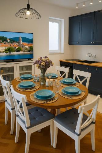 a kitchen with a wooden table with blue plates on it at Mala Kuća in Hodilje