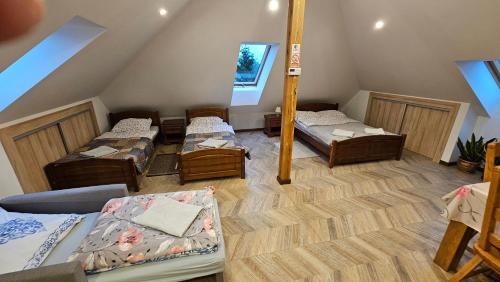 a room with four beds in a attic at Agroturystyka Pokój na Skarpie in Kowale Oleckie