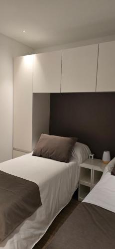 a bedroom with two beds and a nightstand between them at Abaco Suites departamentos premium La Plata in La Plata