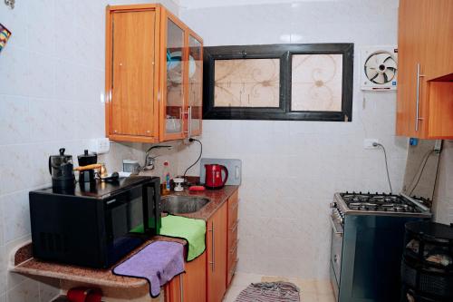 a small kitchen with a sink and a microwave at Tranquil Villa in Fayoum Private Pool Garden Lake Access in Kaḩk al Baḩrīyah