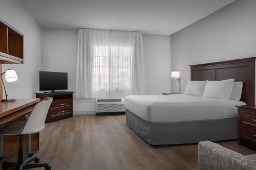 a bedroom with a bed and a desk and a television at TownePlace Suites El Centro in El Centro