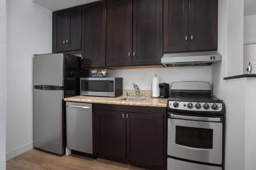 a kitchen with black cabinets and a stainless steel refrigerator at TownePlace Suites El Centro in El Centro