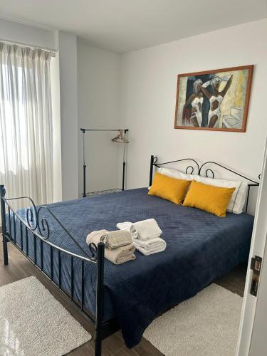a bedroom with a bed with blue sheets and yellow pillows at Ocean House in Santa Cruz