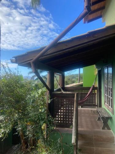 a porch of a house with a hammock on it at Pousada vale verde bungalows - Praia do Rosa in Praia do Rosa