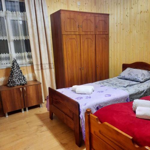 a bedroom with two beds and a wooden cabinet at Nugzar House Chakvi - 2 Bedrooms in Chakvi