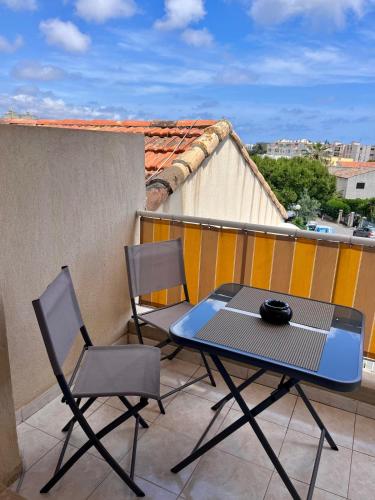 d'une table de patio et de 2 chaises sur un balcon. dans l'établissement Chez Mika - Studio avec piscine, à La Celle-sous-Gouzon