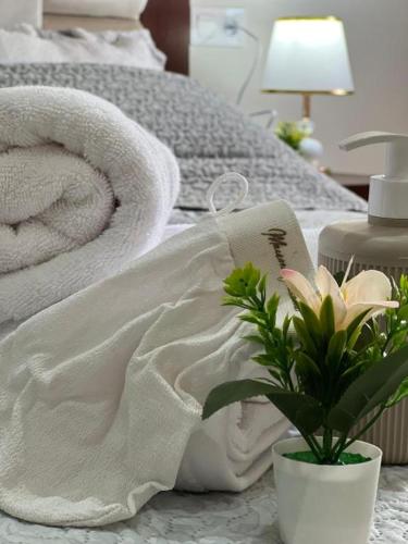 a bed with white towels and a vase with a flower at Casa del Mar in Asilah
