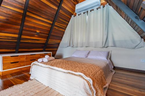 a bedroom with a bed and a wooden ceiling at Villa Estoril in Campina Grande do Sul