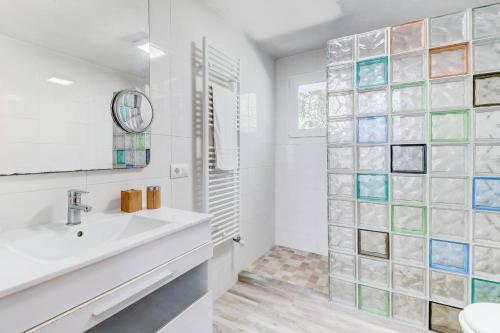 a bathroom with a sink and a glass walled shower at Villa Maite by Villa Plus in El Port