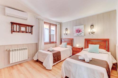 a hotel room with two beds and a window at Villa Maite by Villa Plus in El Port
