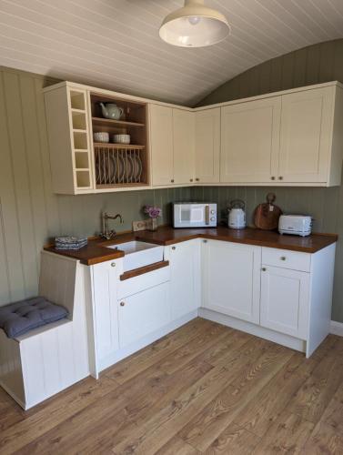 a kitchen with white cabinets and a sink at Rose Valley Ballycastle in Ballycastle