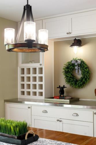 a kitchen with white cabinets and a green wreath on the wall at Maple City Farm Pet Friendly in Maple City