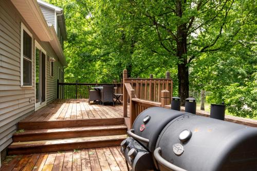 a grill sitting on a wooden deck next to a house at Maple City Farm Pet Friendly in Maple City