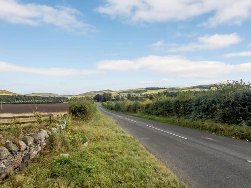 a road next to a river with hills in the background at 2 Bed in Mindrum 85422 in Carham