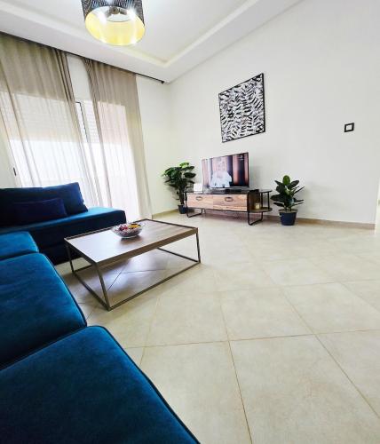 a living room with a blue couch and a table at 5-star hillside relaxation in Imi Ouaddar
