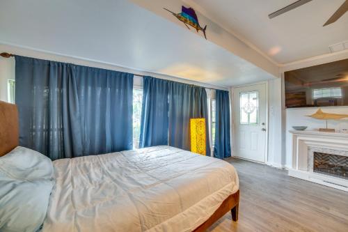 a bedroom with a bed with blue curtains and a fireplace at 7 Mi to Boating and Fishing Quitman Guest Suite in Quitman