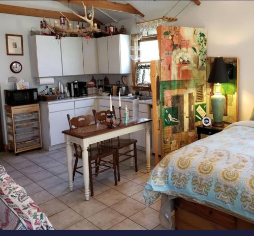 a kitchen with a table and a bed in a room at Tortuga Inn in Winamac