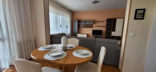einen Esstisch mit Stühlen und ein Sofa in der Unterkunft ALIANA apartment in Sečovlje