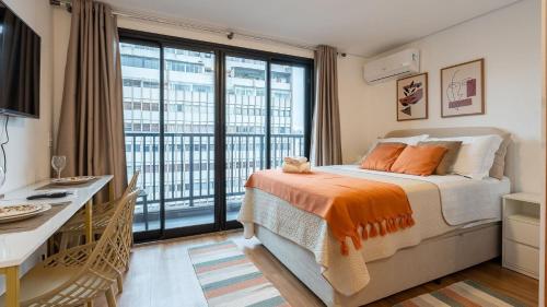 una camera da letto con un letto e una grande finestra di Studios modernos e luxuosos na Vila Buarque com piscina no Rooftop a San Paolo