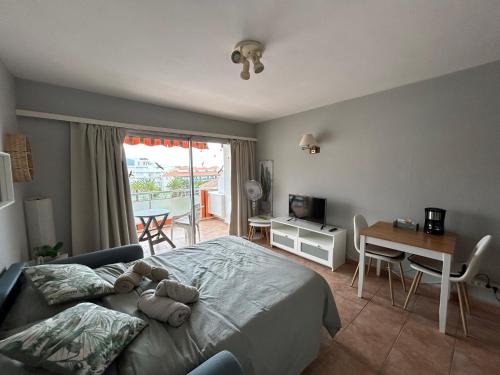 Un dormitorio con una cama con un osito de peluche encima. en Aceviño Solimar, en Puerto de la Cruz