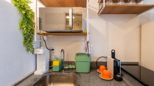 un bancone da cucina con lavello e microonde di Studios modernos e luxuosos na Vila Buarque com piscina no Rooftop a San Paolo