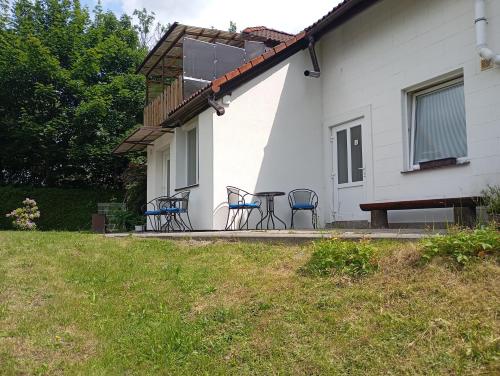 a patio with chairs and a table in front of a house at Penzion U Hyklů in Veřovice