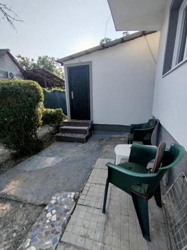 a patio with two chairs and a door at Apartman Deni in Tuzla
