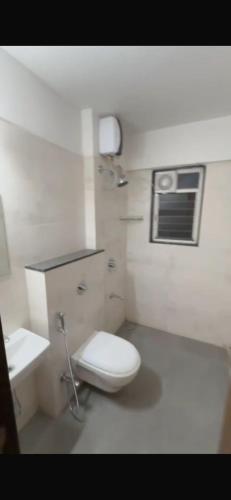 a white bathroom with a toilet and a sink at 3Bhk Bungalow Baner in Pune