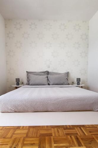 a bedroom with a large white bed with two side tables at ALIANA apartment in Sečovlje
