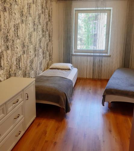 a bedroom with two beds and a window at Pajūrio namai in Juodkrantė
