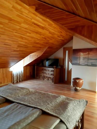 a room with a bed and a wooden ceiling at Pajūrio namai in Juodkrantė