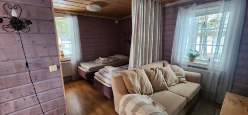 a living room with a couch and a window at Smedjan in Mellanström