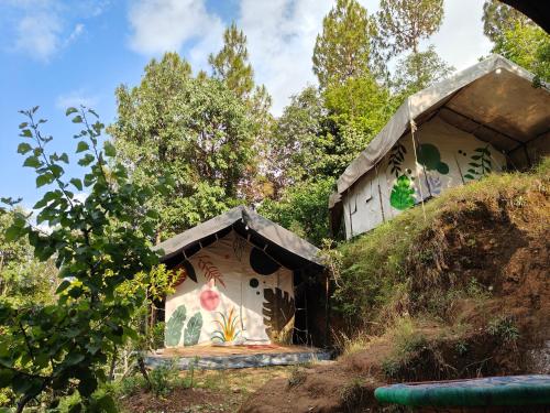 a house with a painting on the side of it at Nayantaara by lake & woods in Mukteswar
