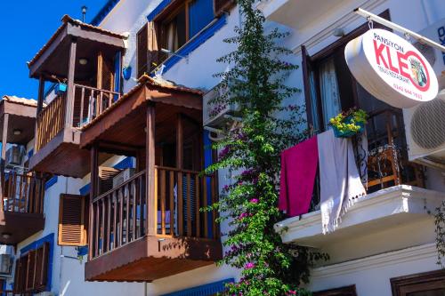 a building with balconies and a nes sign on it at Kalkan Kleo Pension Guesthouse in Kalkan